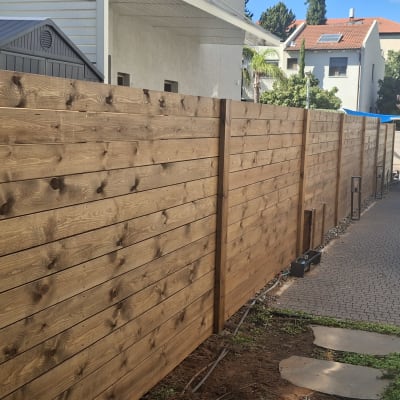 גדר עץ חומה לאורך שביל מרוצף