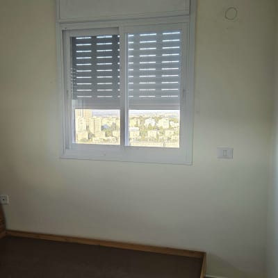 חלון אלומיניום עם תריסים סגורים חלקית