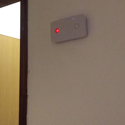 מכשיר חשמלי עם נורות אדומה וכחולה על קיר