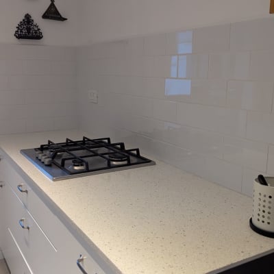 כיריים על משטח עבודה במטבח עם אריחי קיר לבנים