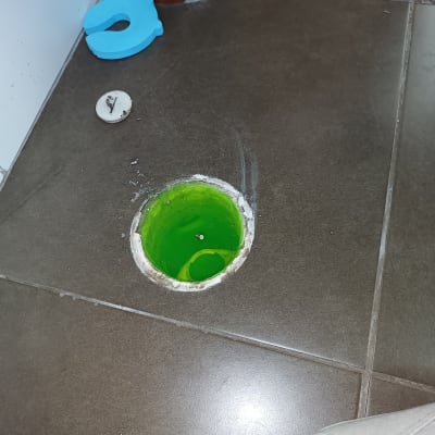 פתח ניקוז ברצפה עם נוזל ירוק