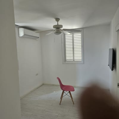 חדר ריק עם כיסא ורוד על רצפת עץ