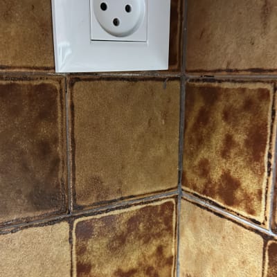 שקע חשמלי על קיר עם אריחים חומים