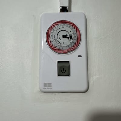 טיימר חשמלי עם כפתור הפעלה על קיר