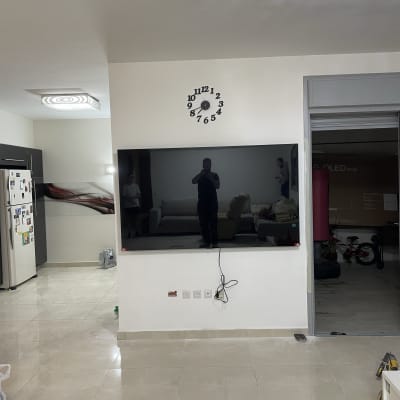 טלוויזיה תלויה על הקיר עם כבלים חשמליים