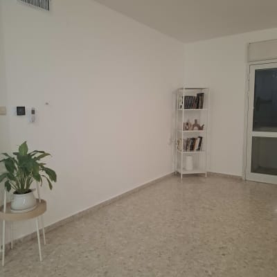 חדר עם קיר לבן ורצפת שיש