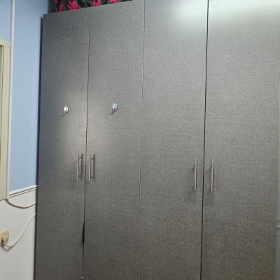 מזוודה צבעונית על ארון בגדים אפור