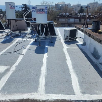 איטום גג עם חומר לבן בין לוחות בטון