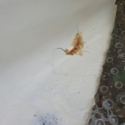 סדק באמבטיה עם סימני חלודה וקצף