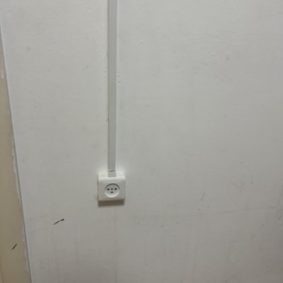 שקע חשמל על קיר לבן עם כבל חשמל