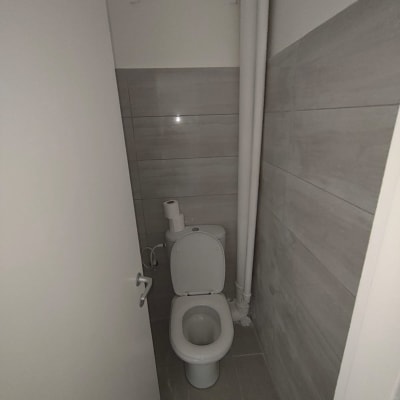 שירותים עם קירות מחופים באריחים אפורים