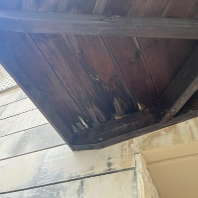 Wooden roof structure with visible damage and discoloration