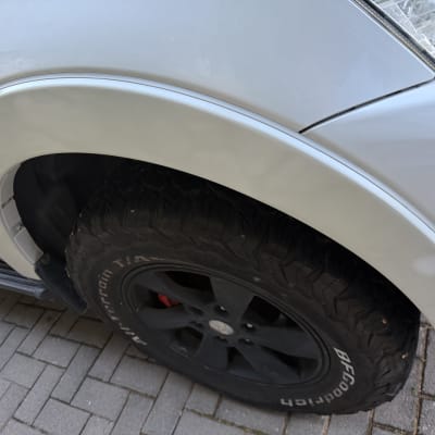 תקריב של גלגל רכב עם צמיג על מדרכה