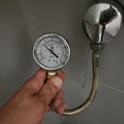 מד לחץ מים מחובר לצינור לבדיקה