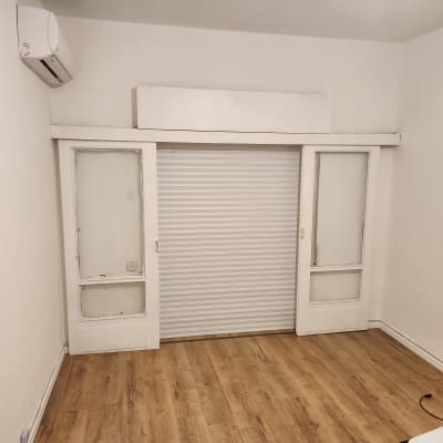 תריס גלילה לבן בין שני חלונות זכוכית