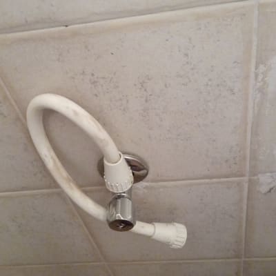 צינור מים לבן מחובר לקיר עם ברז