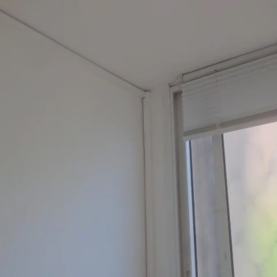 חלון עם תריסים סגורים וקיר לבן