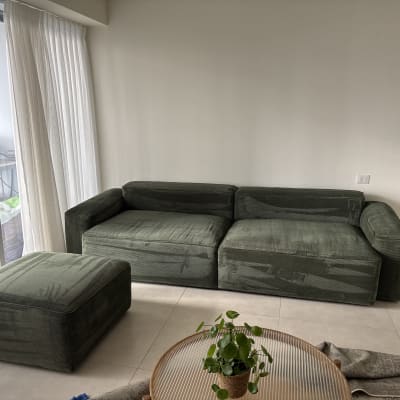 ספה ירוקה עם הדום על רצפת אריחים