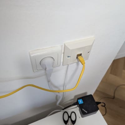 כבל רשת מחובר לשקע בקיר עם ציוד טכני נוסף