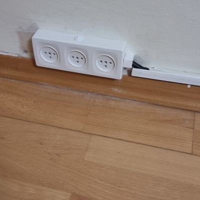 שקע חשמל על קיר עם רצפת עץ