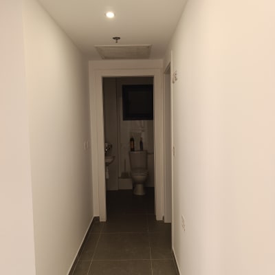 מסדרון צבוע עם קירות לבנים ותאורה עליונה