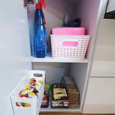 מוצרי ניקוי ומטליות בסלסלה בארון מטבח