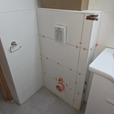 עבודת אינסטלציה עם צינורות וקיר אריחים