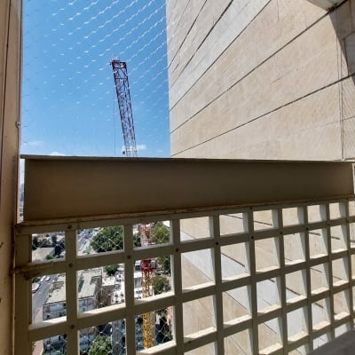 רשת יונים מותקנת על מרפסת בבניין גבוה