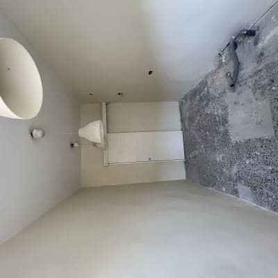 קירות צבועים בלבן עם רצפה חשופה