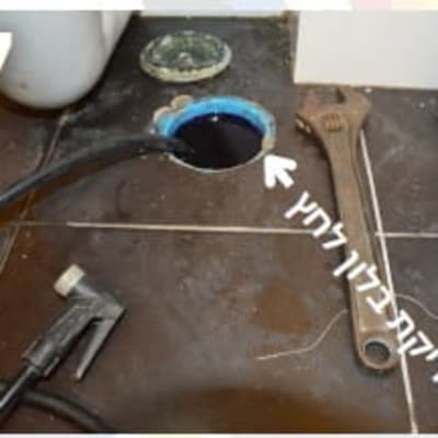 כלי עבודה ליד פתח ביוב על רצפה
