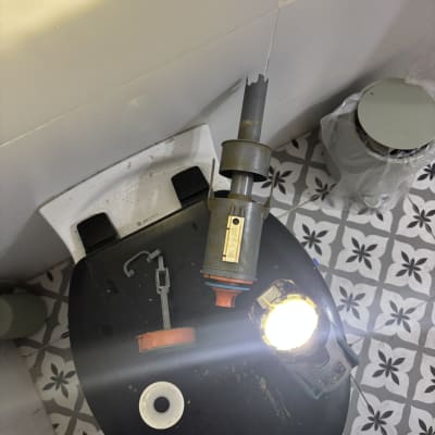 חלקי מנגנון ניאגרה מפורקים על מכסה אסלה במהלך תיקון אינסטלציה