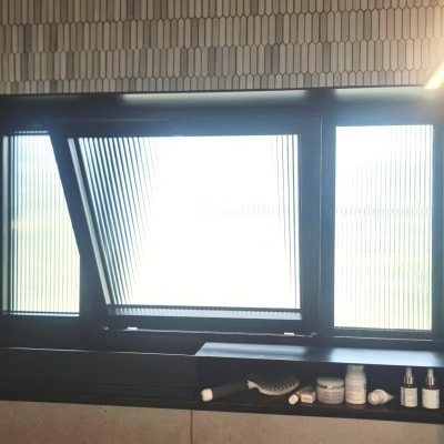 חלון עם מסגרת כהה ומדף עם מוצרי טיפוח