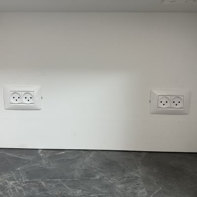 שני שקעים חשמליים מותקנים על קיר לבן