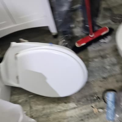 אסלה הפוכה על הרצפה עם מטאטא אדום