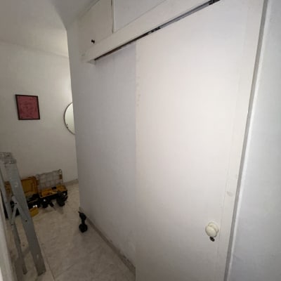 כלי עבודה וסולם במסדרון עם דלת לבנה