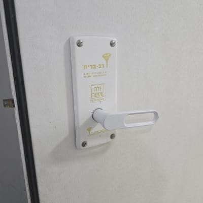 ידית דלת לבנה עם מנעול על דלת לבנה