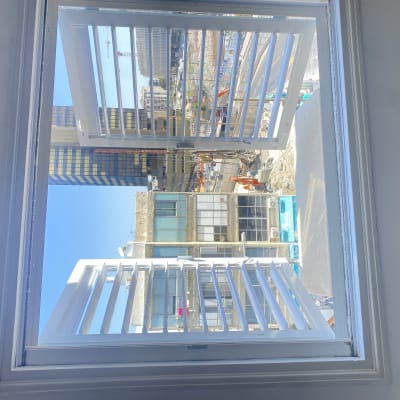 חלון אלומיניום פתוח עם תריסים לבנים