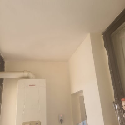 קיר צבוע בלבן עם דלי ומברשת צבע