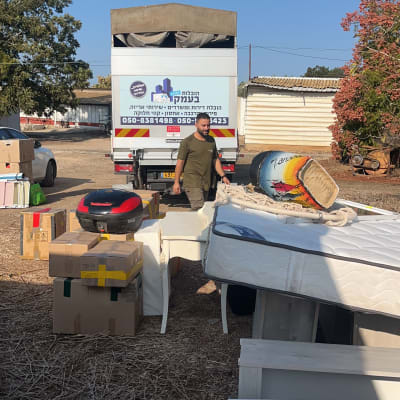 משאית הובלה עם קרטונים ורהיטים בחוץ