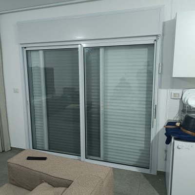 תריסים סגורים על דלת הזזה בחדר מגורים