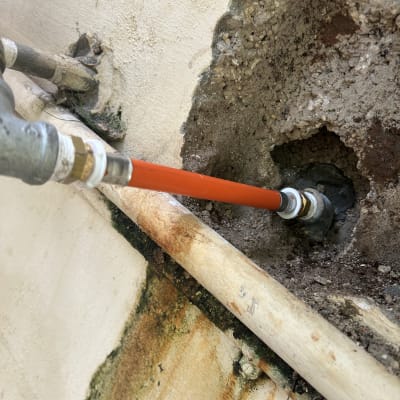 צינור מים מחובר לקיר עם סימני חלודה