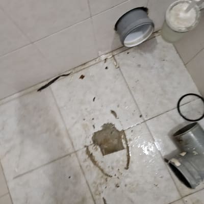צינור ביוב מנותק על רצפה רטובה עם לכלוך