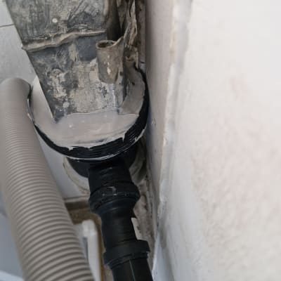 צינור פלסטיק מחובר לקיר עם אטם שחור