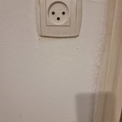 שקע חשמל על קיר לבן עם לכלוך