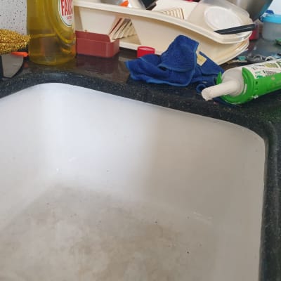 אקדח סיליקון ירוק על השיש ליד הכיור