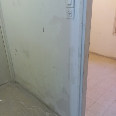 קיר עם סימני צבע ותיקונים, ניילון על הרצפה