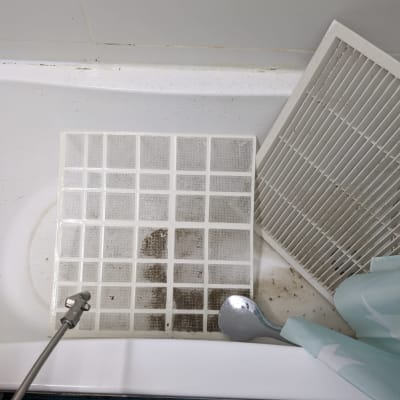 מסנני מזגן מלוכלכים באמבטיה עם ראש מקלחת