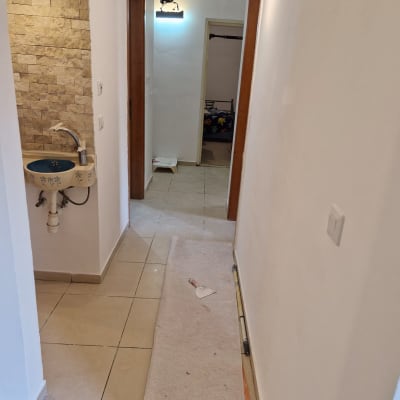 מסדרון עם כיור, כלי עבודה ושטיחון