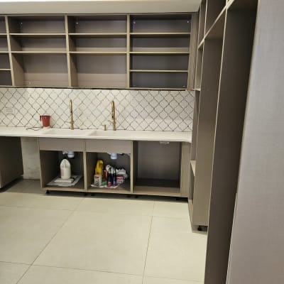 מטבח עם ארונות פתוחים וחומרי ניקוי