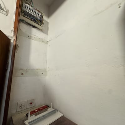 לוח חשמל פתוח עם חוטים, מברגה וכלי עבודה